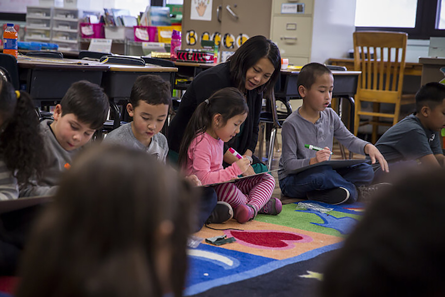 Hmong woman sits with children.