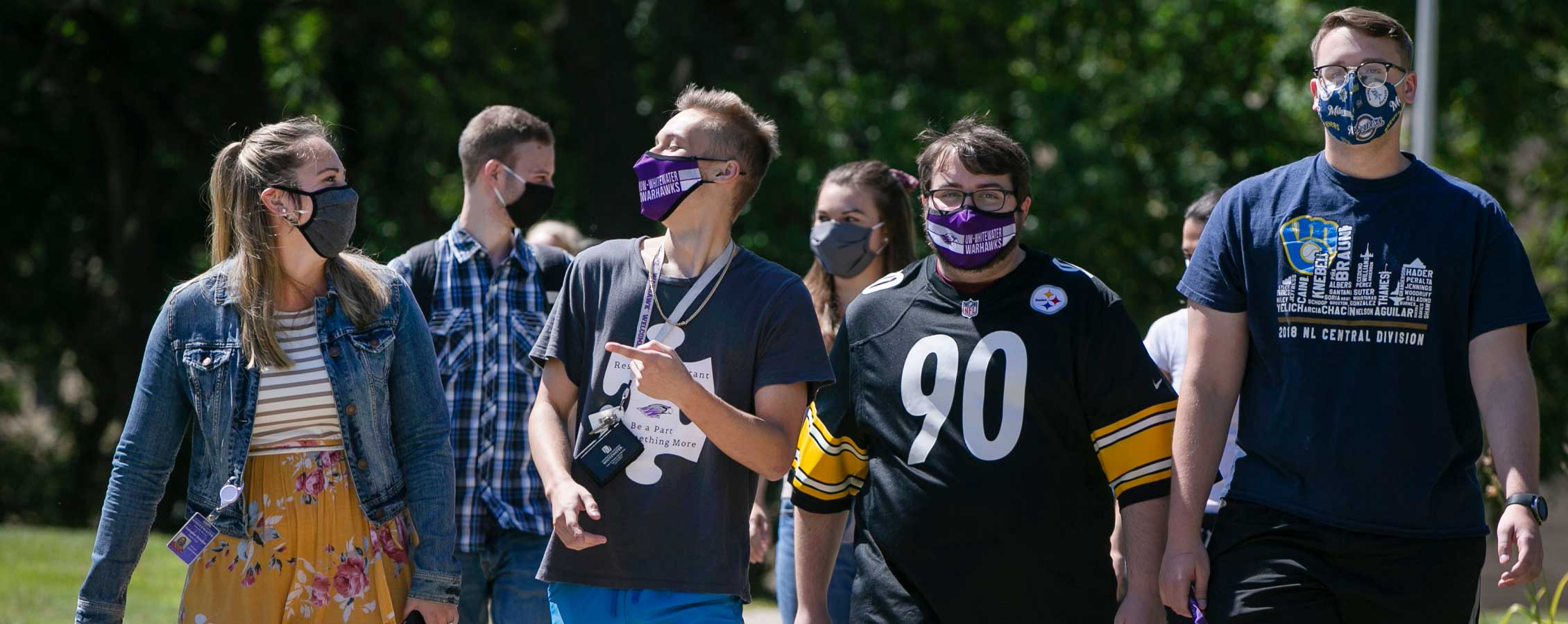 Students walking outside while wearing face coverings.