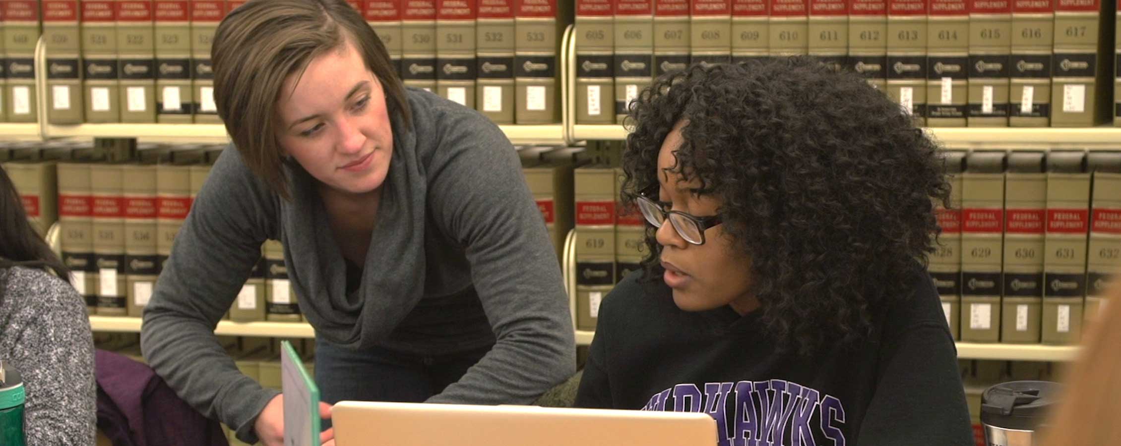 Two students study together in the library.