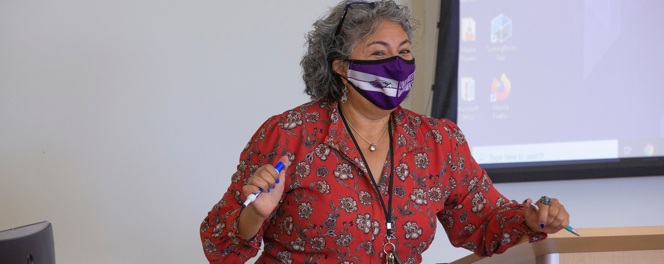 Pilar Melero stands in front of class.