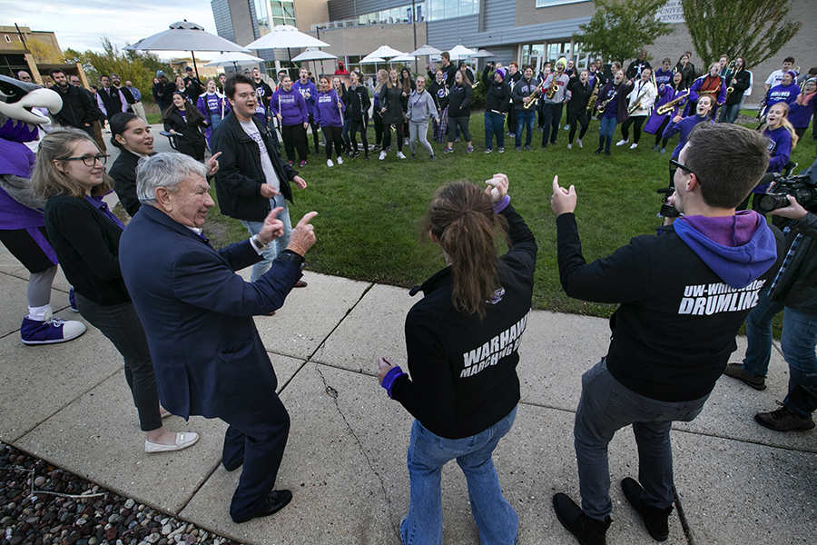 Marching Band teaches Tommy Thompson to do the Warhawk Strut.