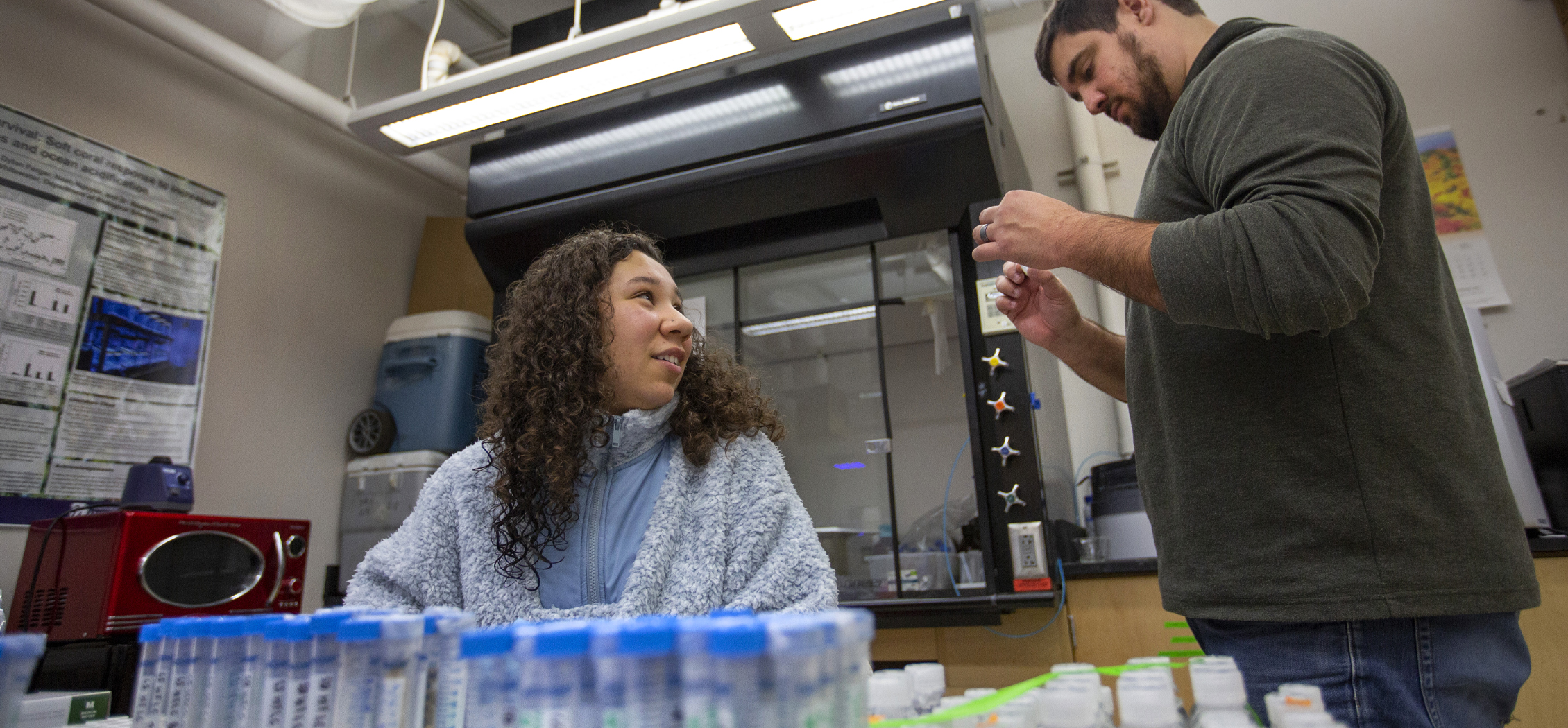 Assistant Professor Stephen Levas discusses samples of crushed soft coral as part of a research project.