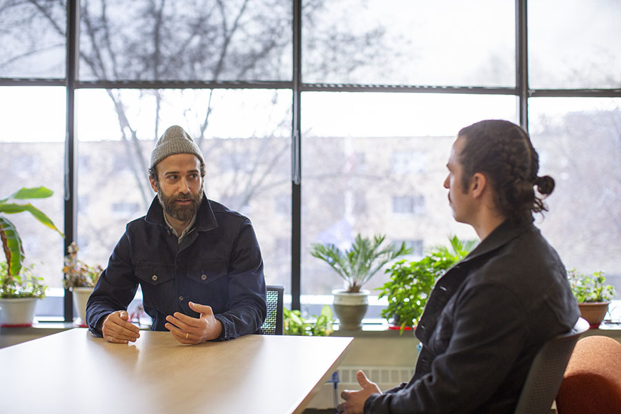 Michael Swanson talks with a faculty member in Laurentide Hall.