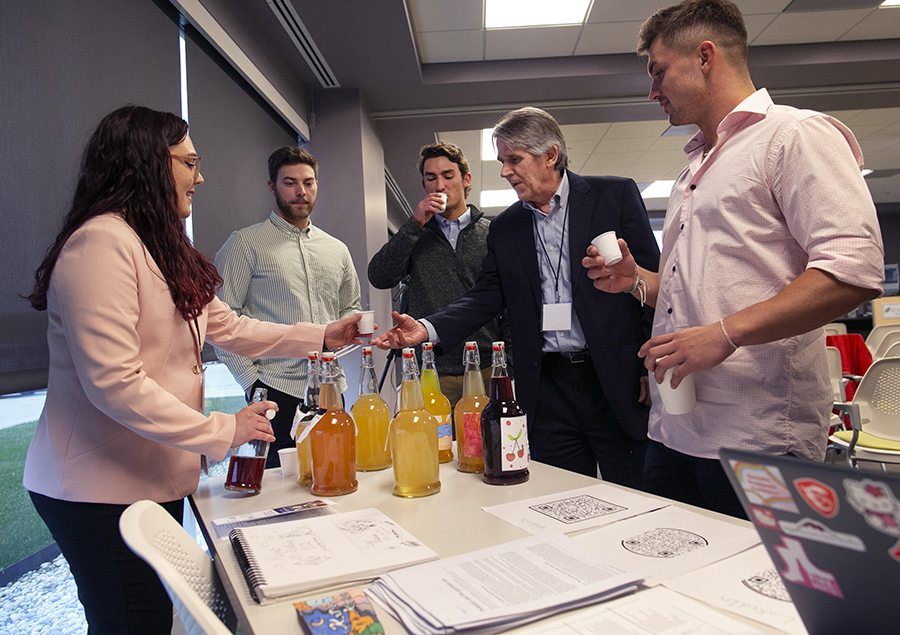 Kara Zamora passes out samples of kombucha to people.