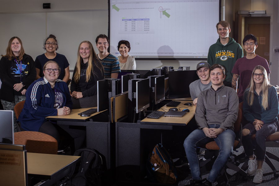 A group of students sit in a classroom facing the camera.