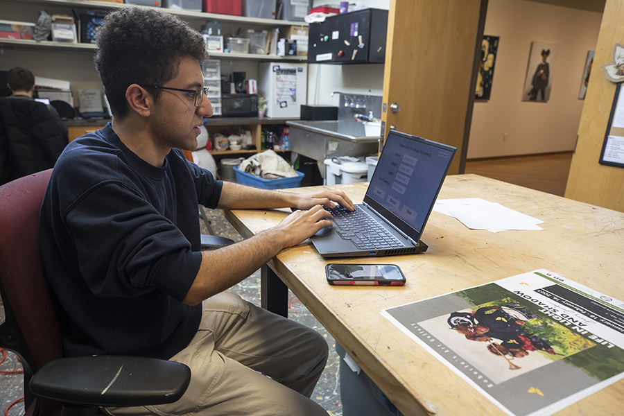 MAGD student Brian Michael works behind the scenes at Roberta's Art Gallery in the university Center.