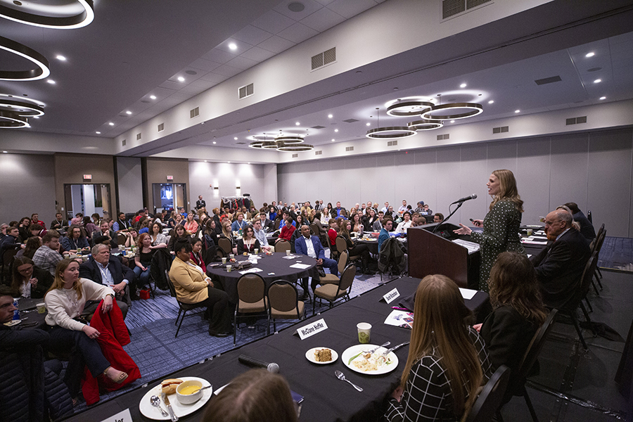 A female student stands at the podium delivering a speech at the Wisconsin Broadcasters Association seminar.