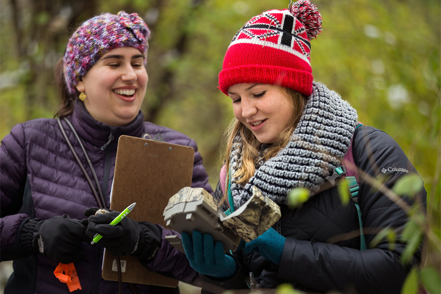 Two women talking in forest.