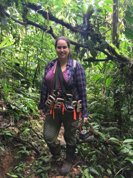 Andrea Romero stands in a forest.