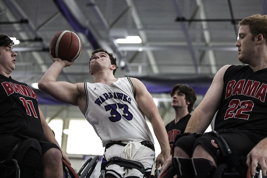 A wheelchair basketball player shoots the ball.