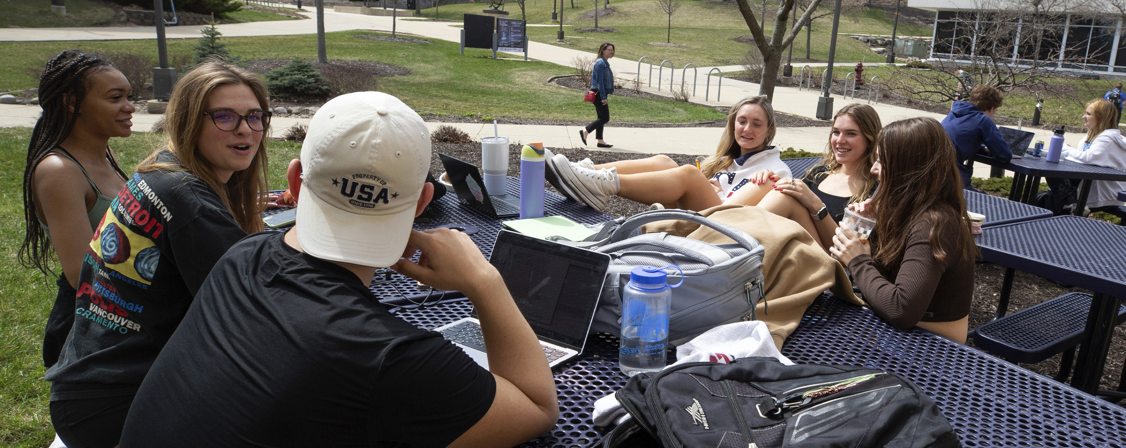 Students sit at a table outside the University Center.