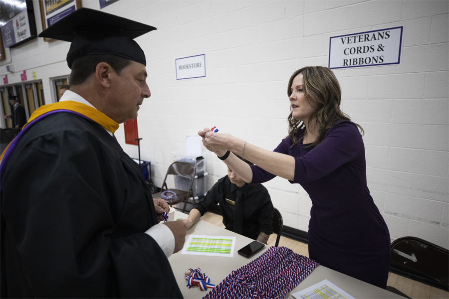 Amy Moore distributes cords at graduation.