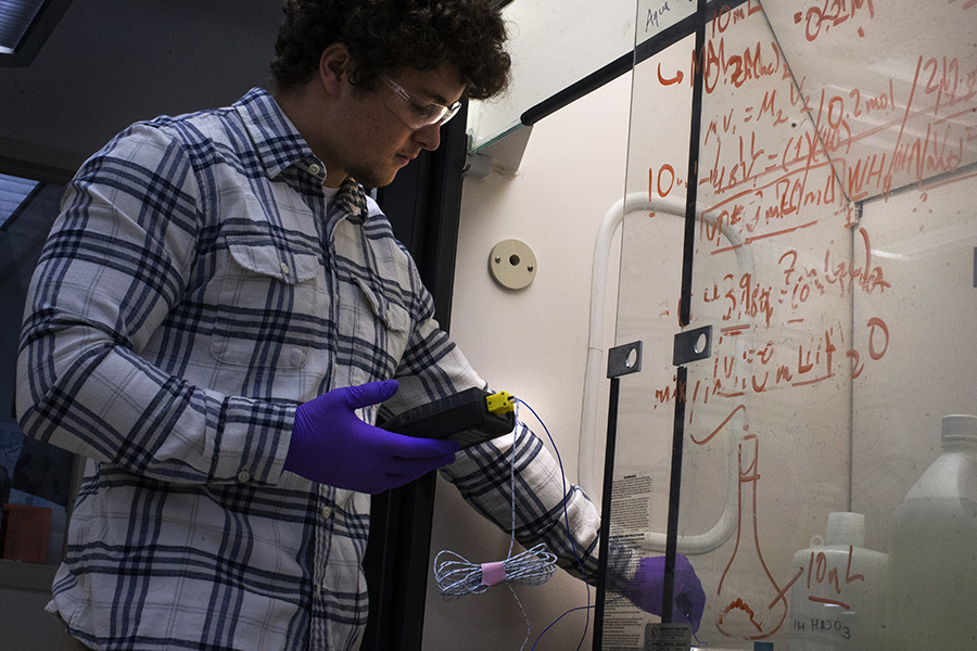 Barmore works on a project while wearing safety goggles.