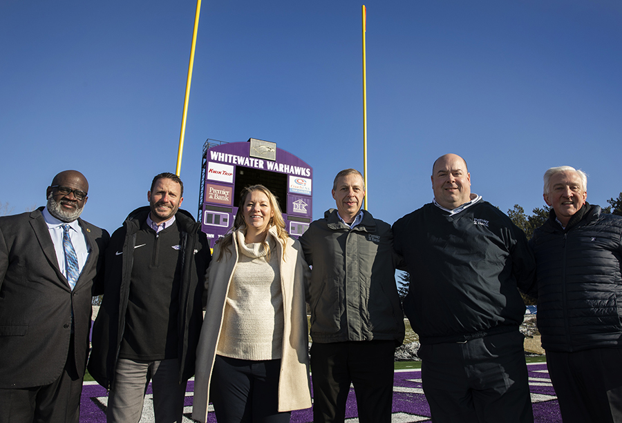 Six people stand and smile at the camera.