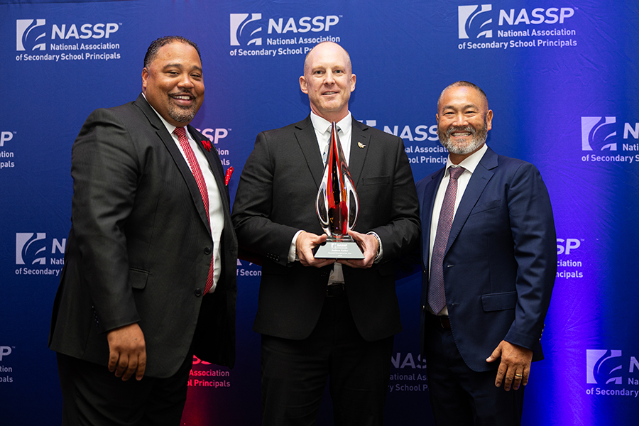 Andy Farley stands in a group holding an award.