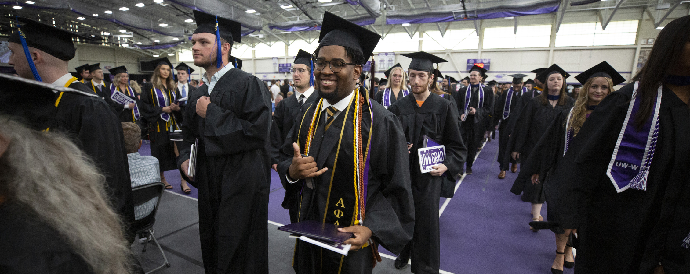 Students line up for graduation in their caps and gowns.