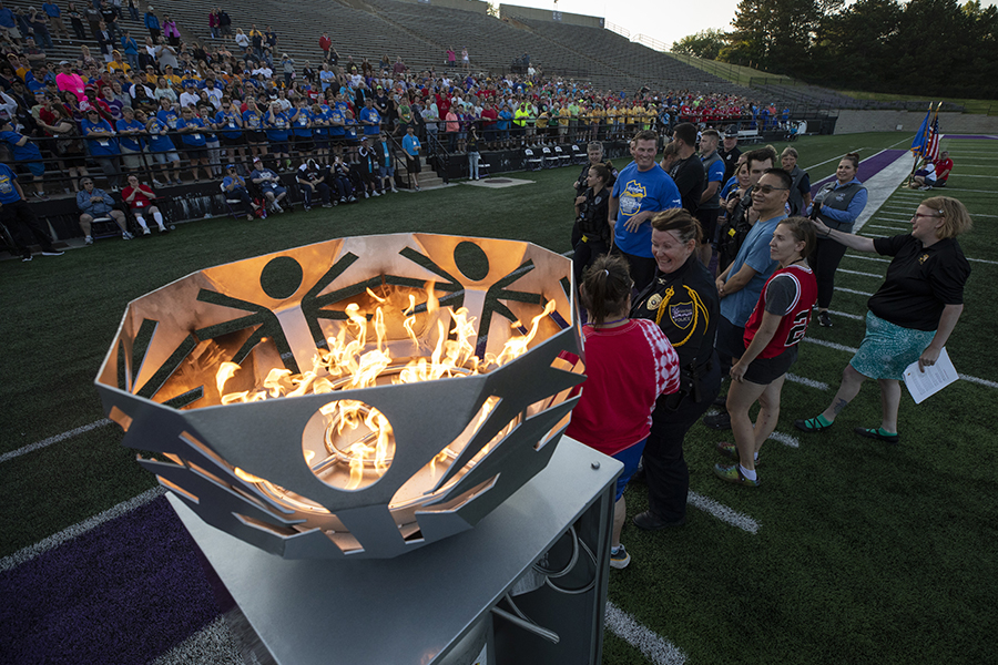 People gather in Perkins Stadium for the opening ceremonies with a fire burning in the cauldron.