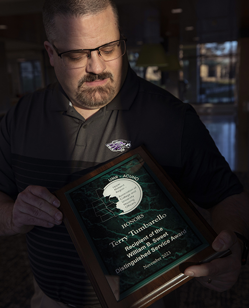 Terry Tumbarello looks at his award.