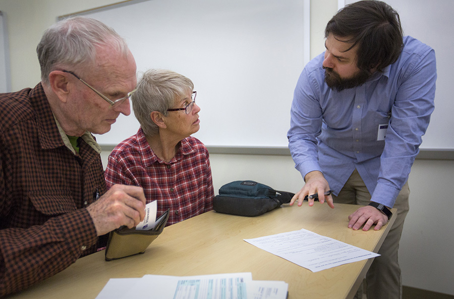 A person helps a couple with their taxes.