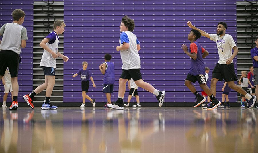 Chislom runs on the basketball court while coaching younger players.