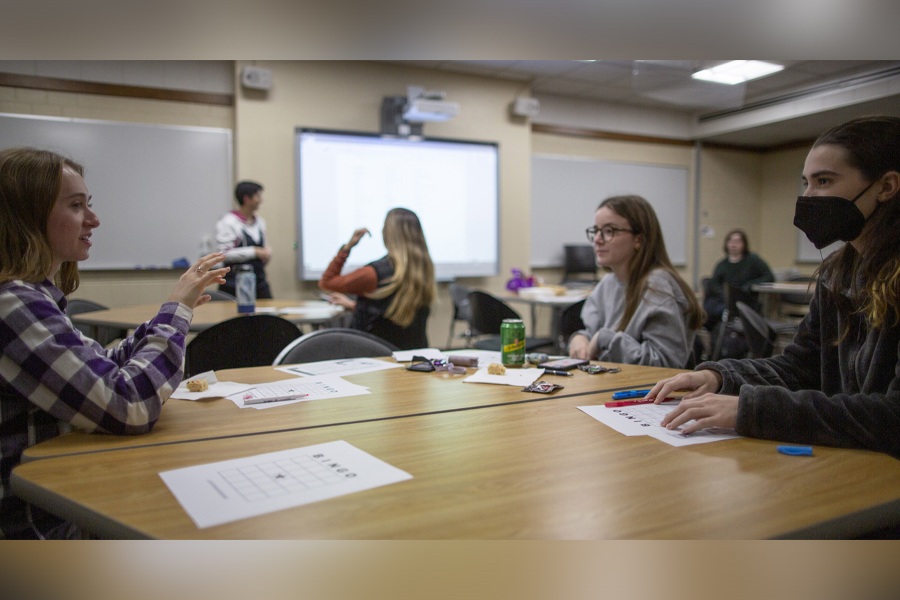 Students in a classroom sit around a table.