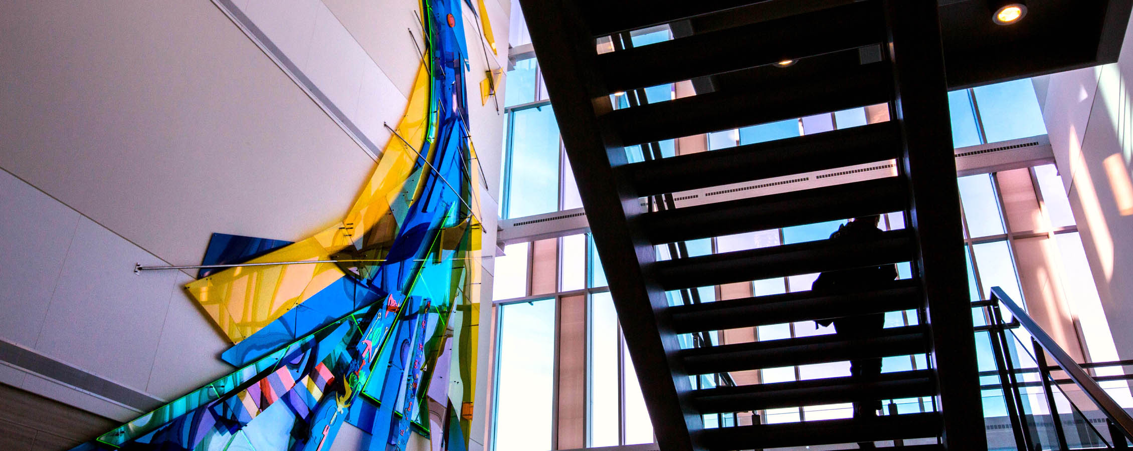 Light comes through the windows and the stairwell in the lobby of Hyland Hall.