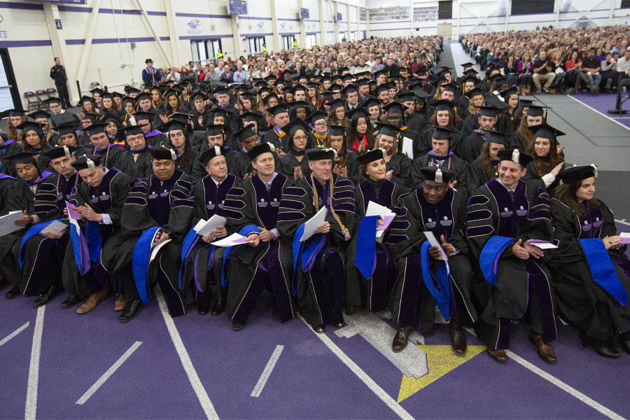 Members of the first cohort of Doctor of Business Administration graduates sit in the front row at Commencement.