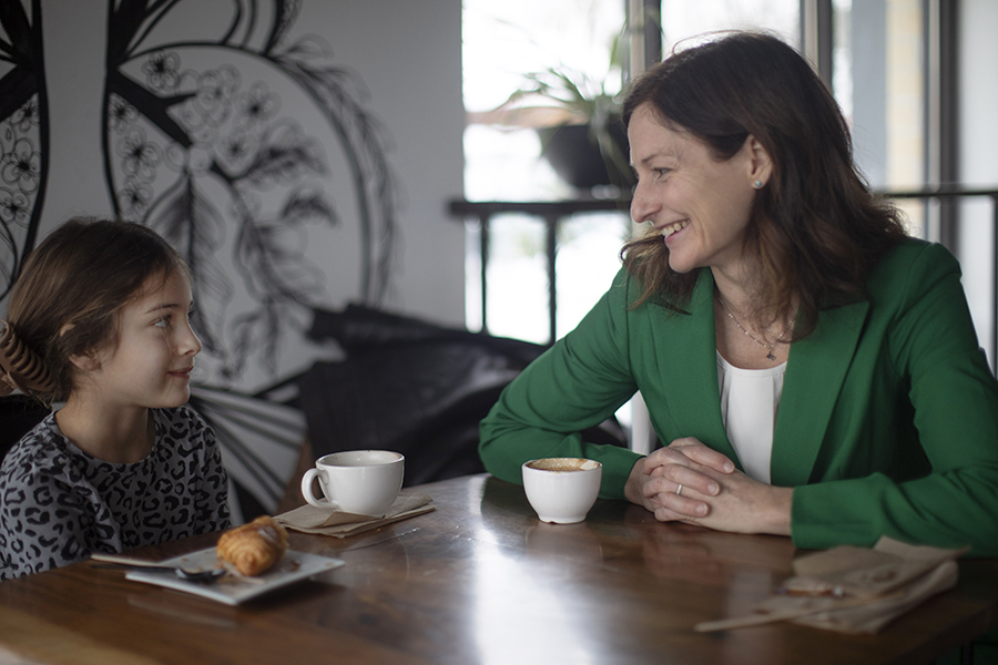 Angela Rachidi looks at her daughter and smiles while they sit at a table.