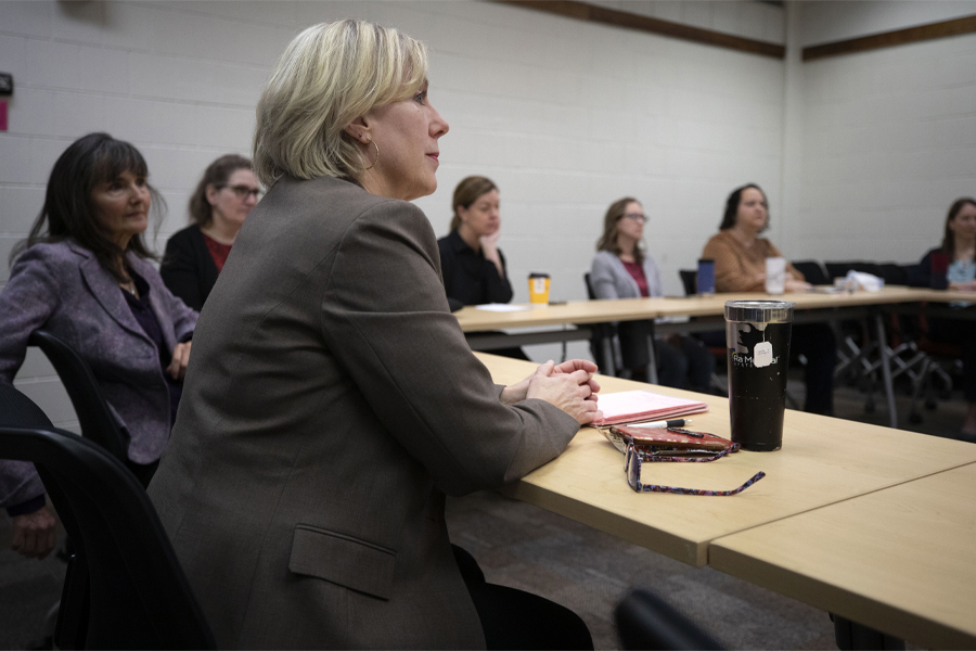 Amy Stevens sits at a table in a meeting.