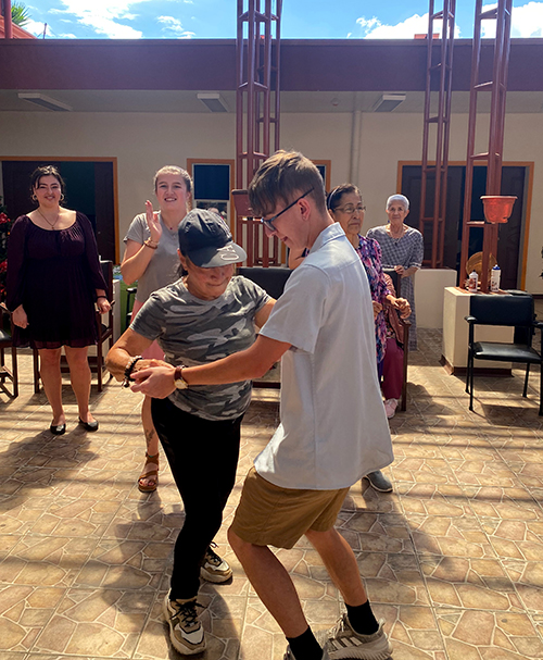 A student dances with a local woman.