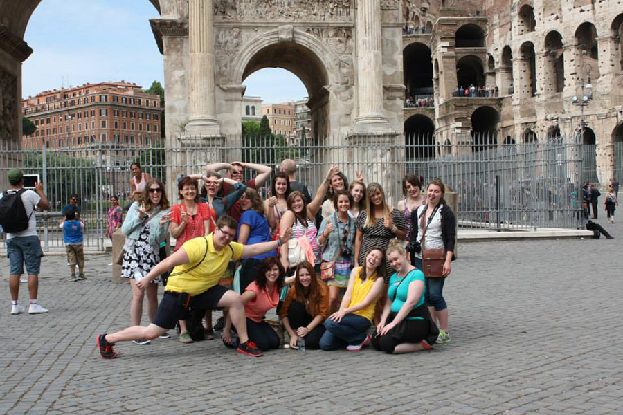 Students and faculty pose in front of ancient ruins.