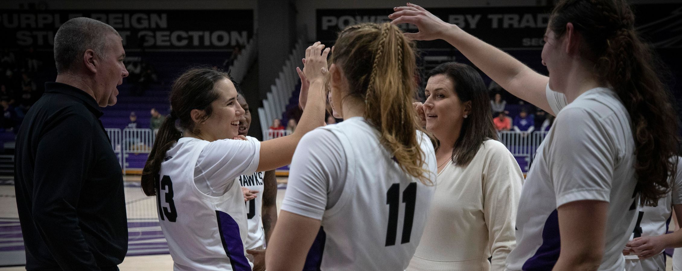Women's basketball are together cheering on eachother.