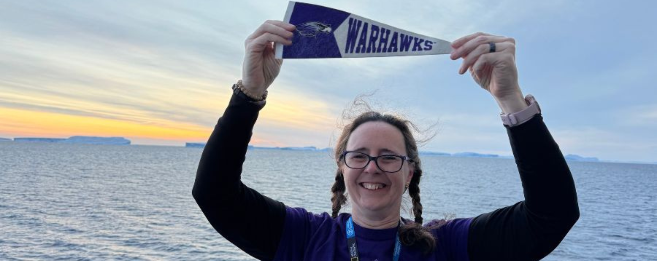 Lisa is holding a college pennant.