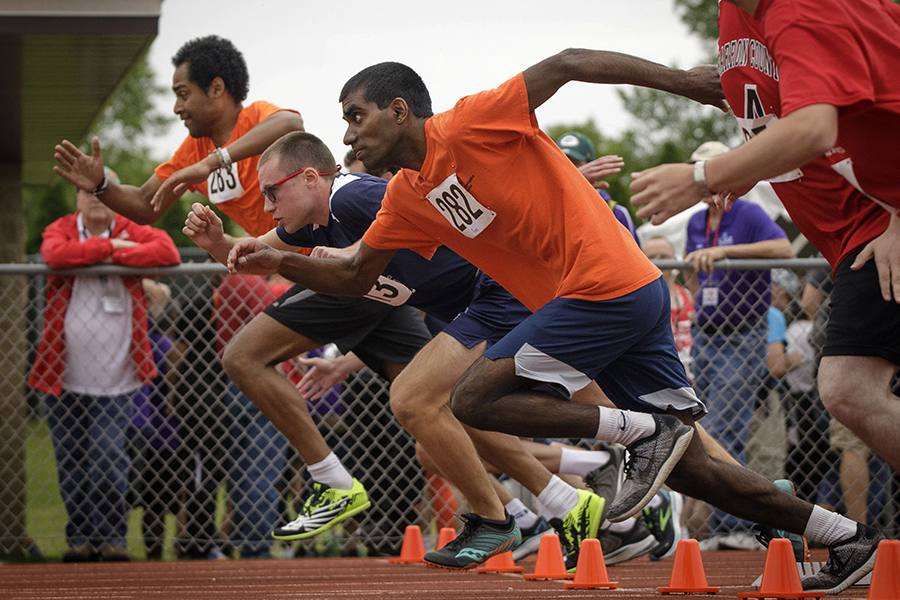 Athletes line up on the starting line on a track.