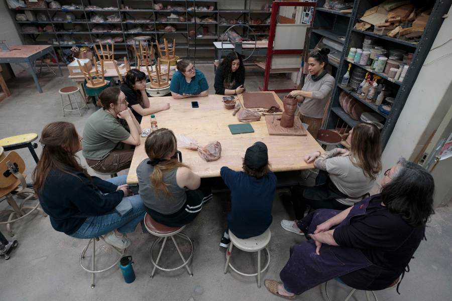 Cristina sitting with students spread on table.