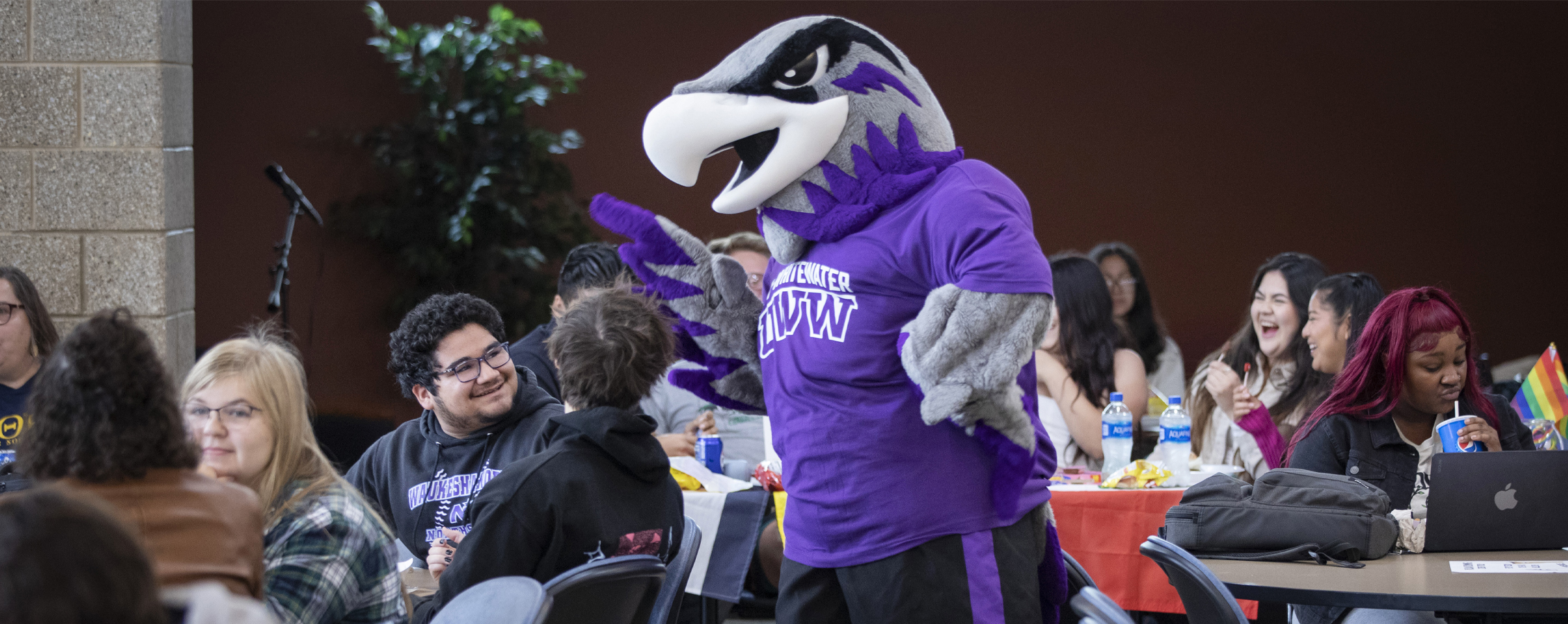 Willie Warhawk engages with a crowd of people.