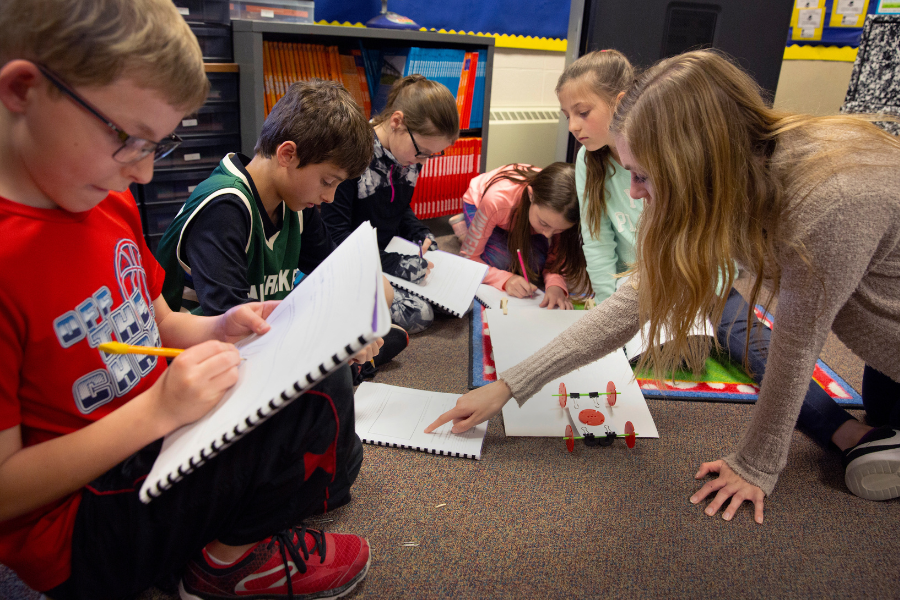 Students are doing activities with notebooks in a classroom.