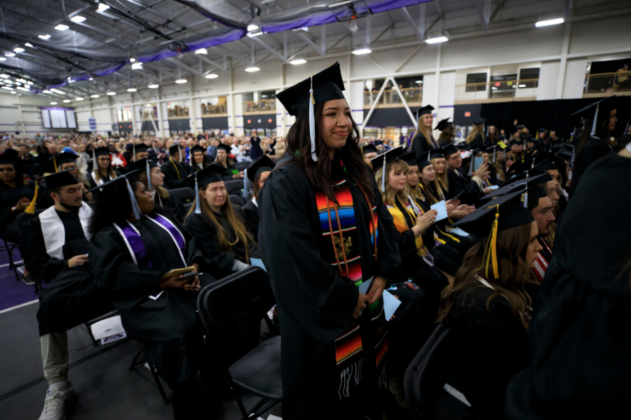 Photo of student standing during commencement.