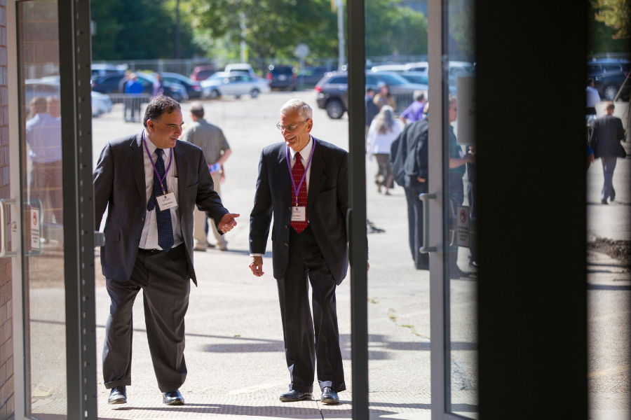Jim and Farshad are walking into building.