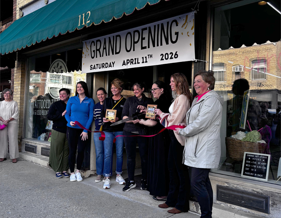 People line up in front of a storefront with a banner that says Grand Opening.