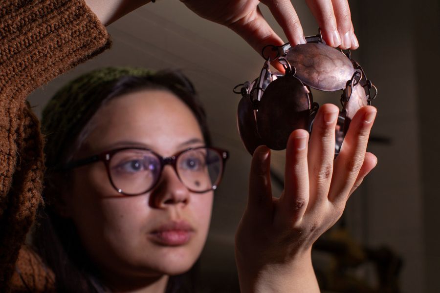 Art student holds an art piece.