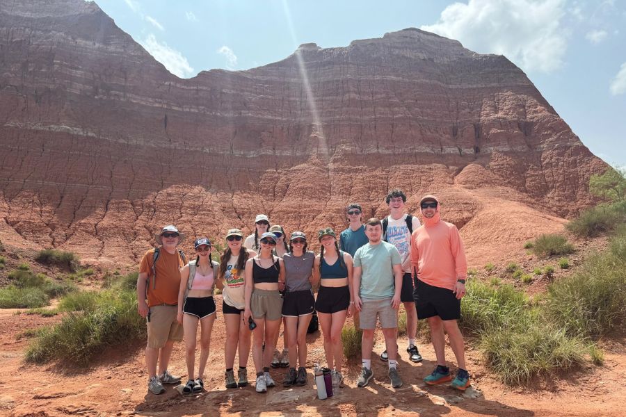 A large group poses for photo after a hike. 