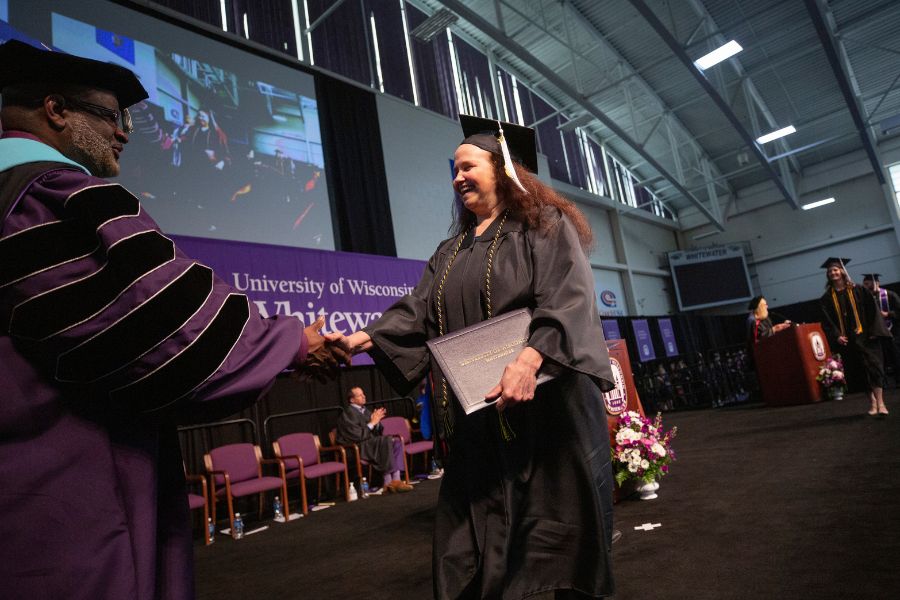 Photo of a graduate walking across stage