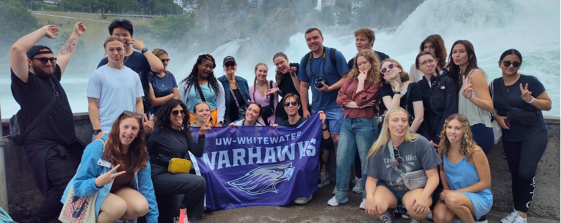 Photo of a group of students posing with Warhawk Flag. 