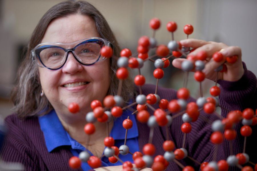 Kim Kostka poses next to science materials.