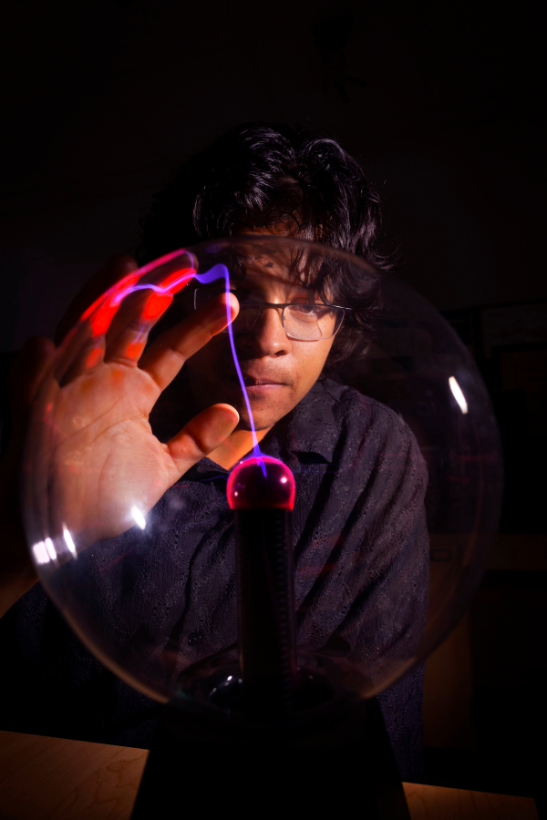 Student is at Upham Hall using hands to show science projects.