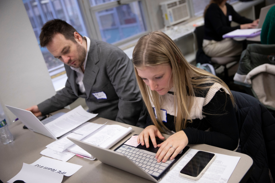 Students are in a class doing work on the computer.