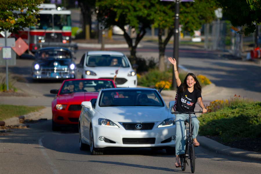 Student is on bike during Enactus parade.