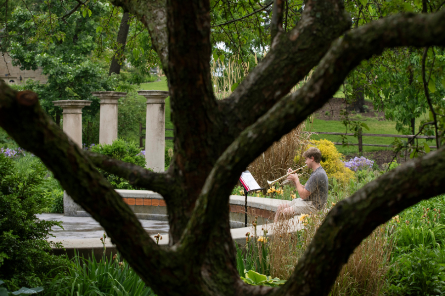 Student plays instrument at the Memory Garden.