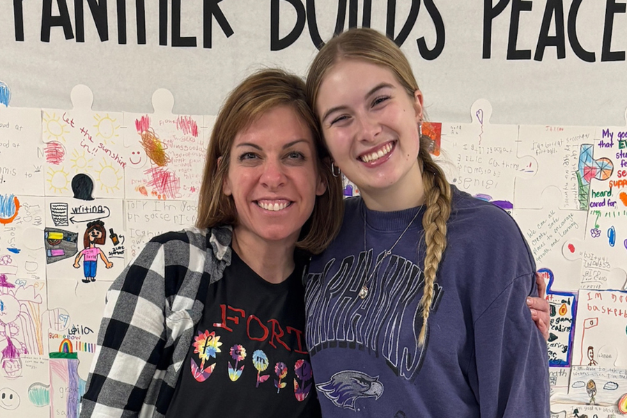 Two people smile and pose for photo at a school.
